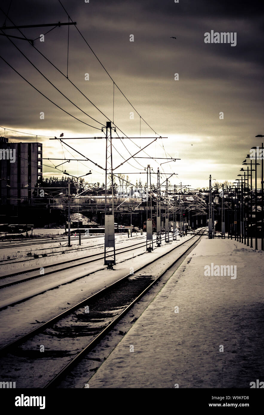view along platform and railway lines at a station near stavanger, norway in winter. Stock Photo