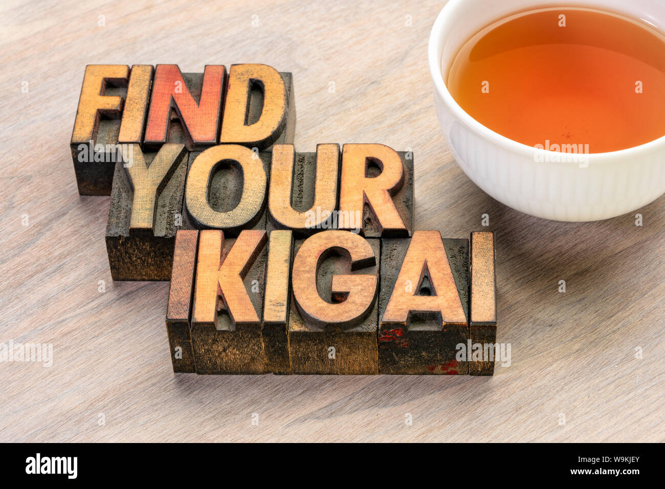 find your ikigai word abstract in vintage letterpress wood type with a cup of tea Japanese