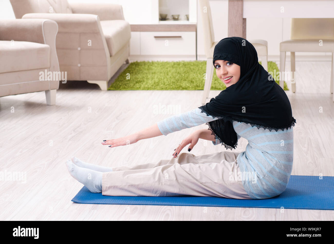 The young woman in hijab doing exercises at home Stock Photo - Alamy