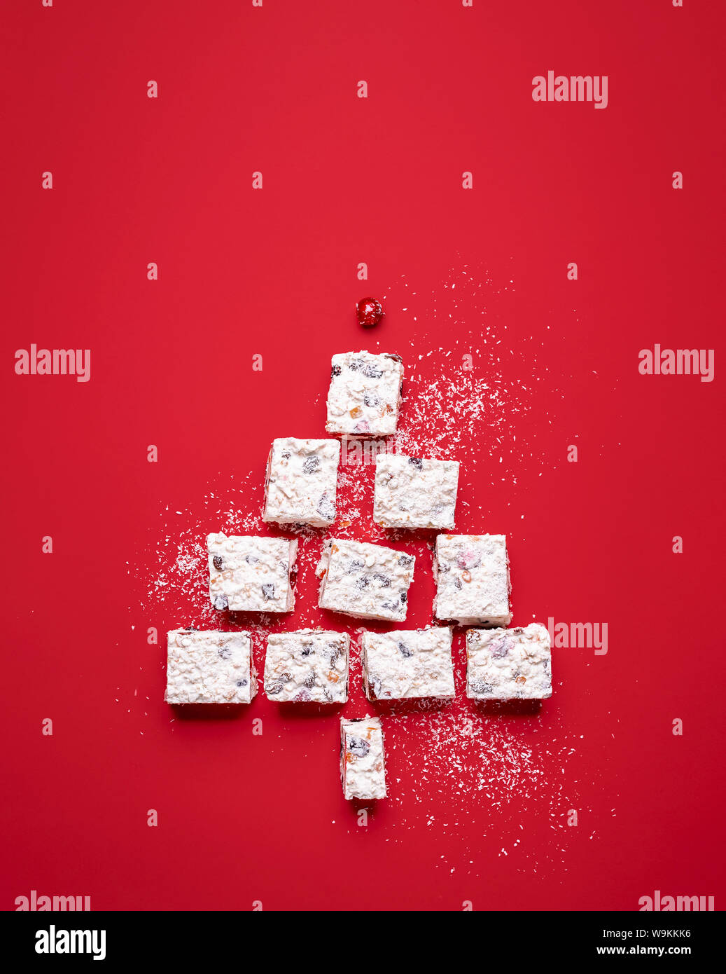 Christmas tree shape made of coconut and dried fruit dessert. Australian traditional Xmas food. White Christmas cake slices in a tree shape. Stock Photo