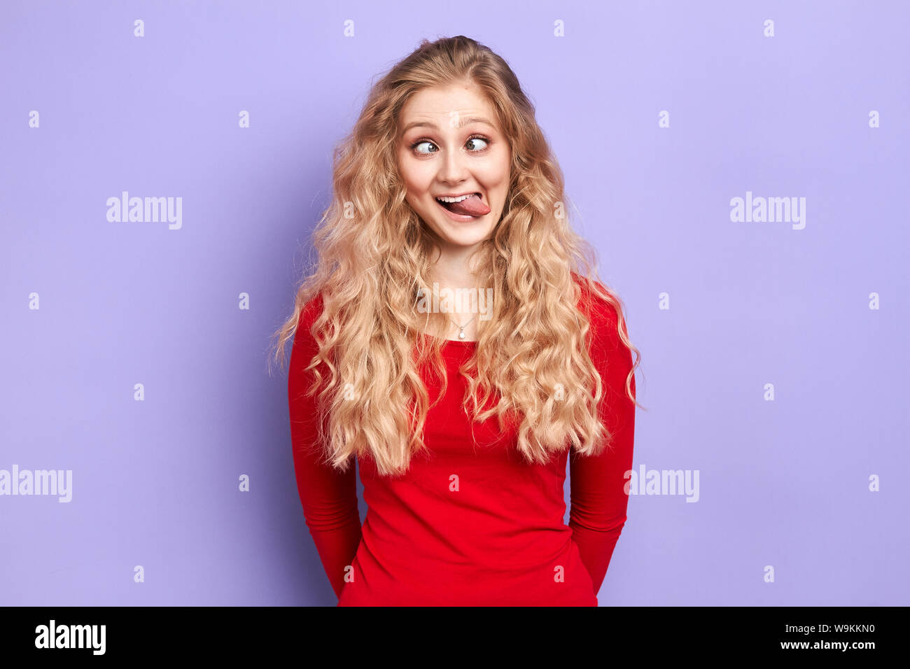 crazy mad woman makes funny face, crosses eyes and sticks her tongue out ,  plays fool, being in good mood. happiness, woman having fun in the studio  Stock Photo - Alamy