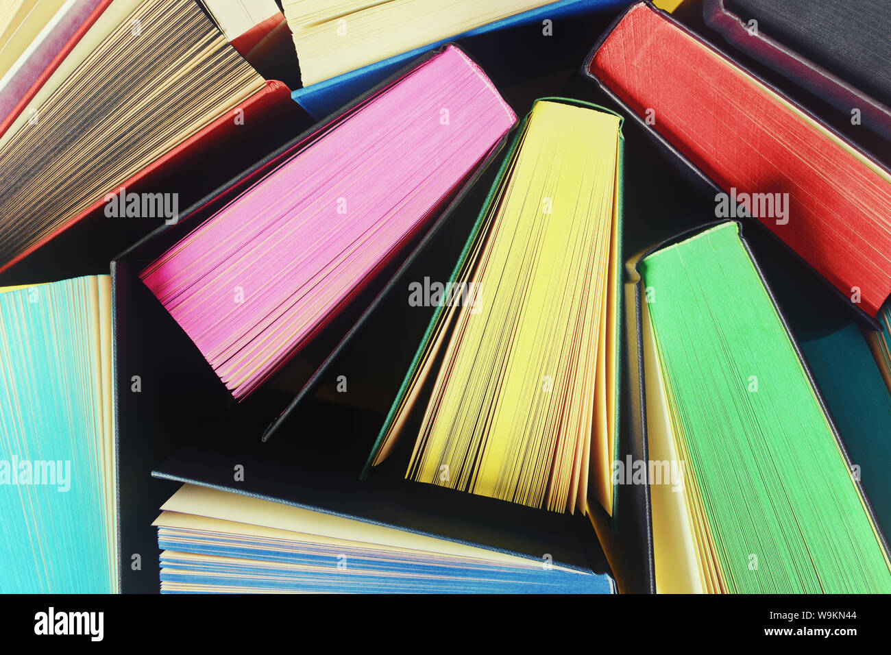Top view of several open books with multicolored sprayed edges Stock