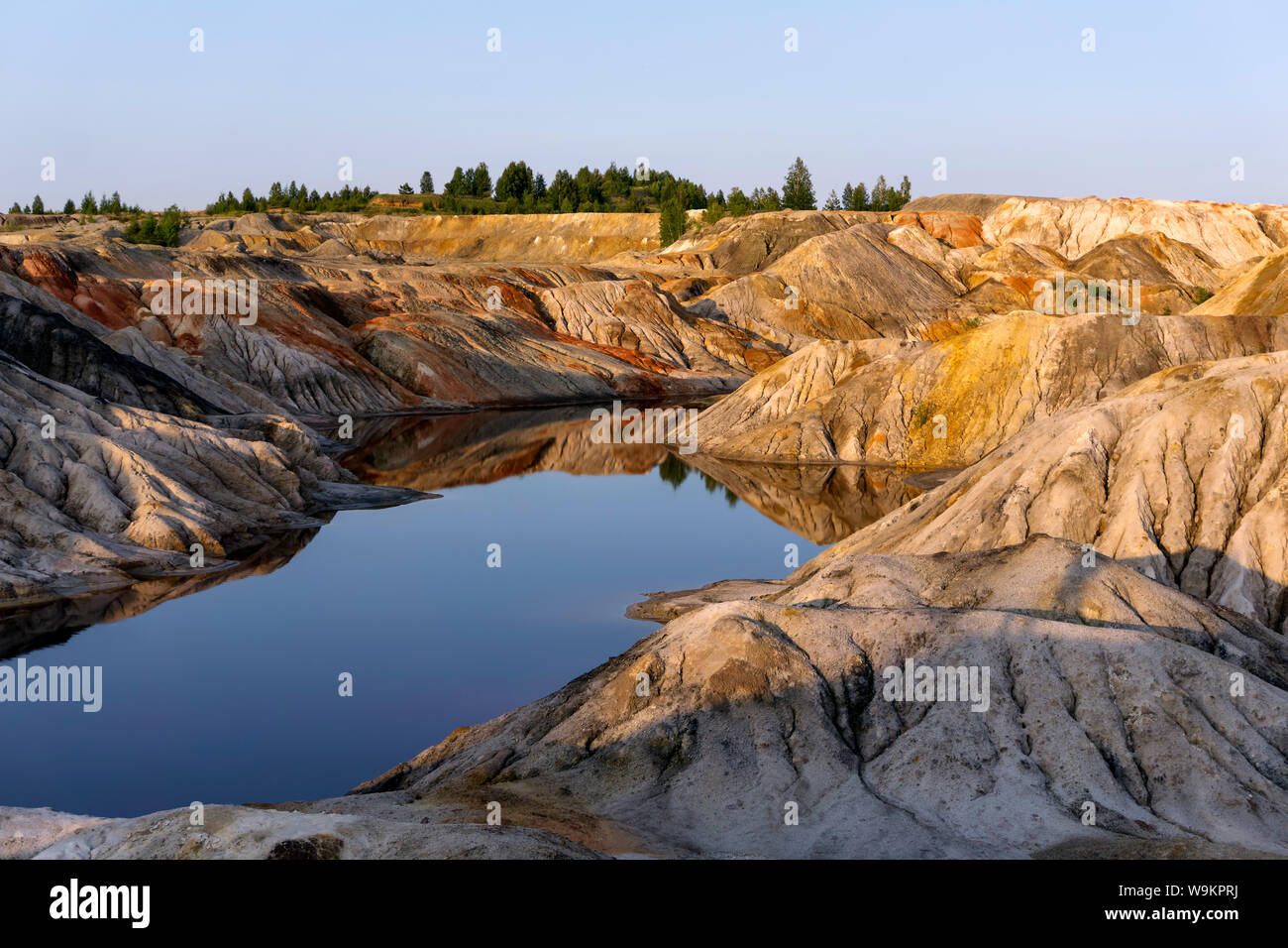 landscape - lake at the bottom of a spent quarry of kaolin mining with beautiful slopes with traces of streams Stock Photo
