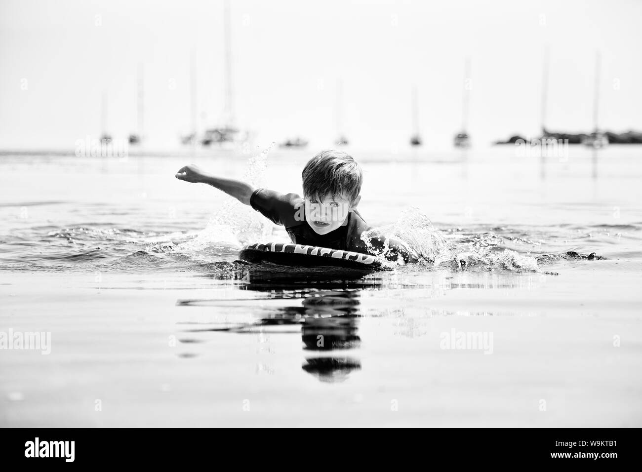 A small boy learning to use a body board Stock Photo