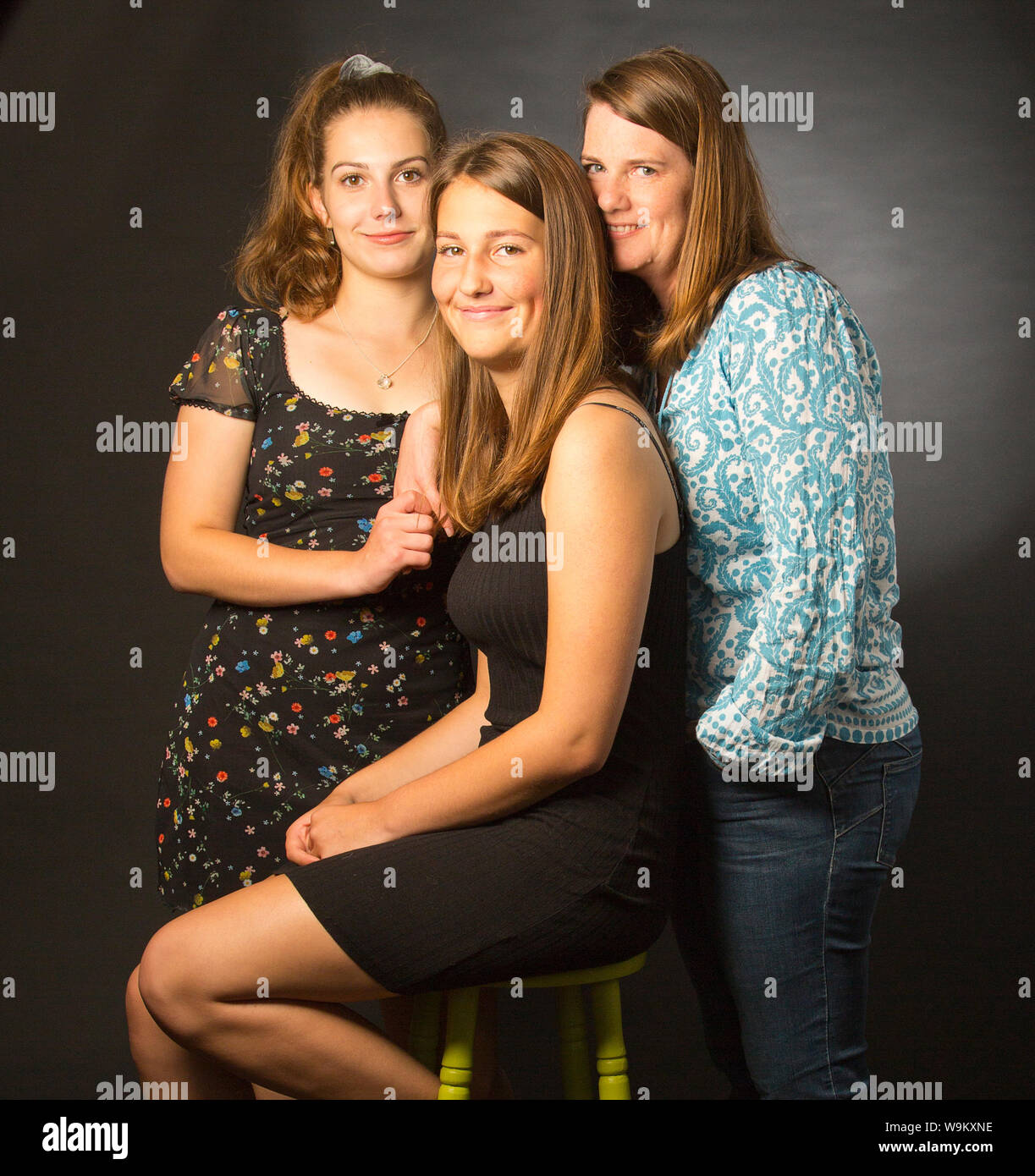 A family portrait of a single mother with her two teenage daughters Stock Photo
