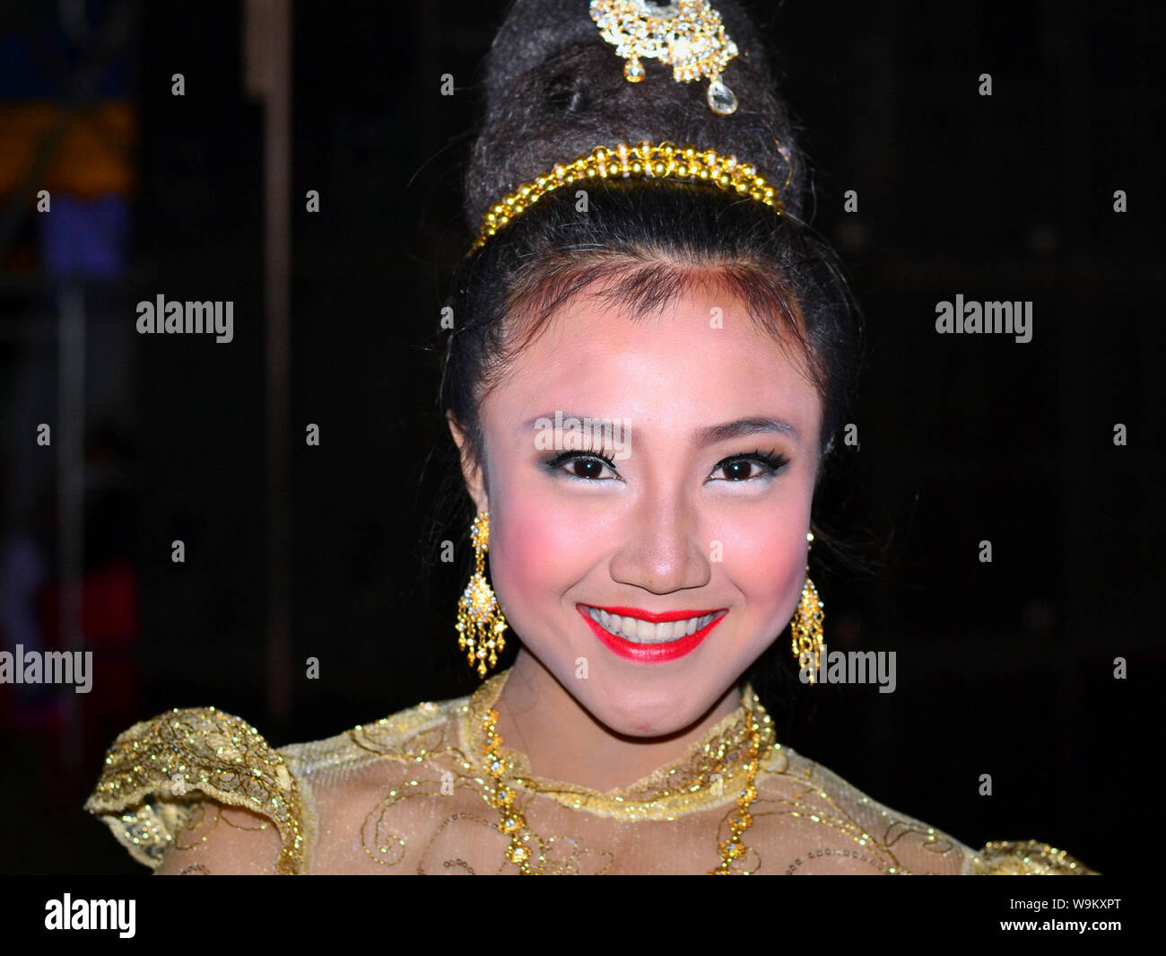 Dressed-up Thai girl wears a golden Lanna-style lace dress and elaborate  hairdo with hair jewellery and drop earrings during a rural Yi Peng parade  Stock Photo - Alamy