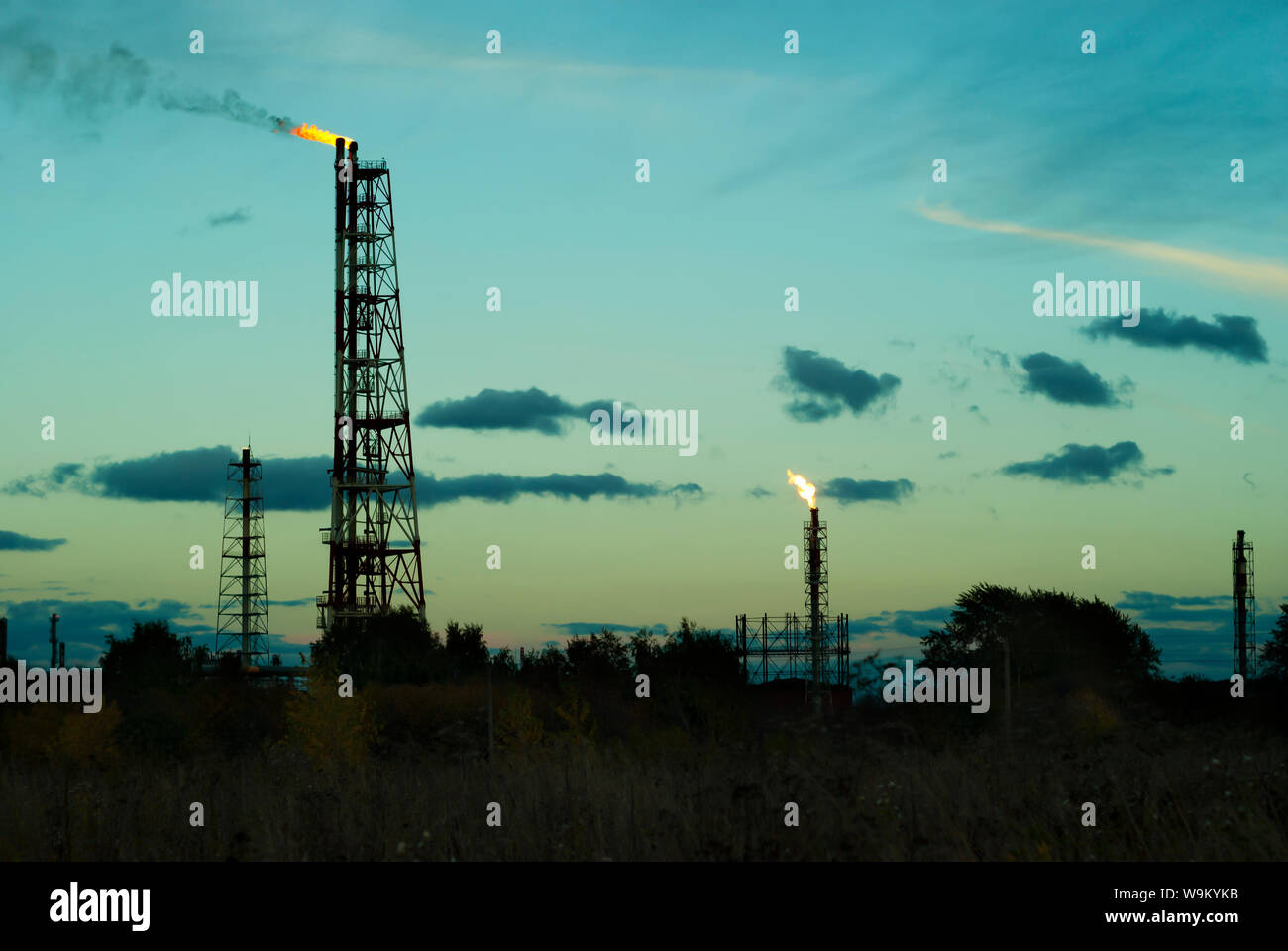 night silhouette industrial landscape - flares for flaring associated gas in an oil field Stock Photo