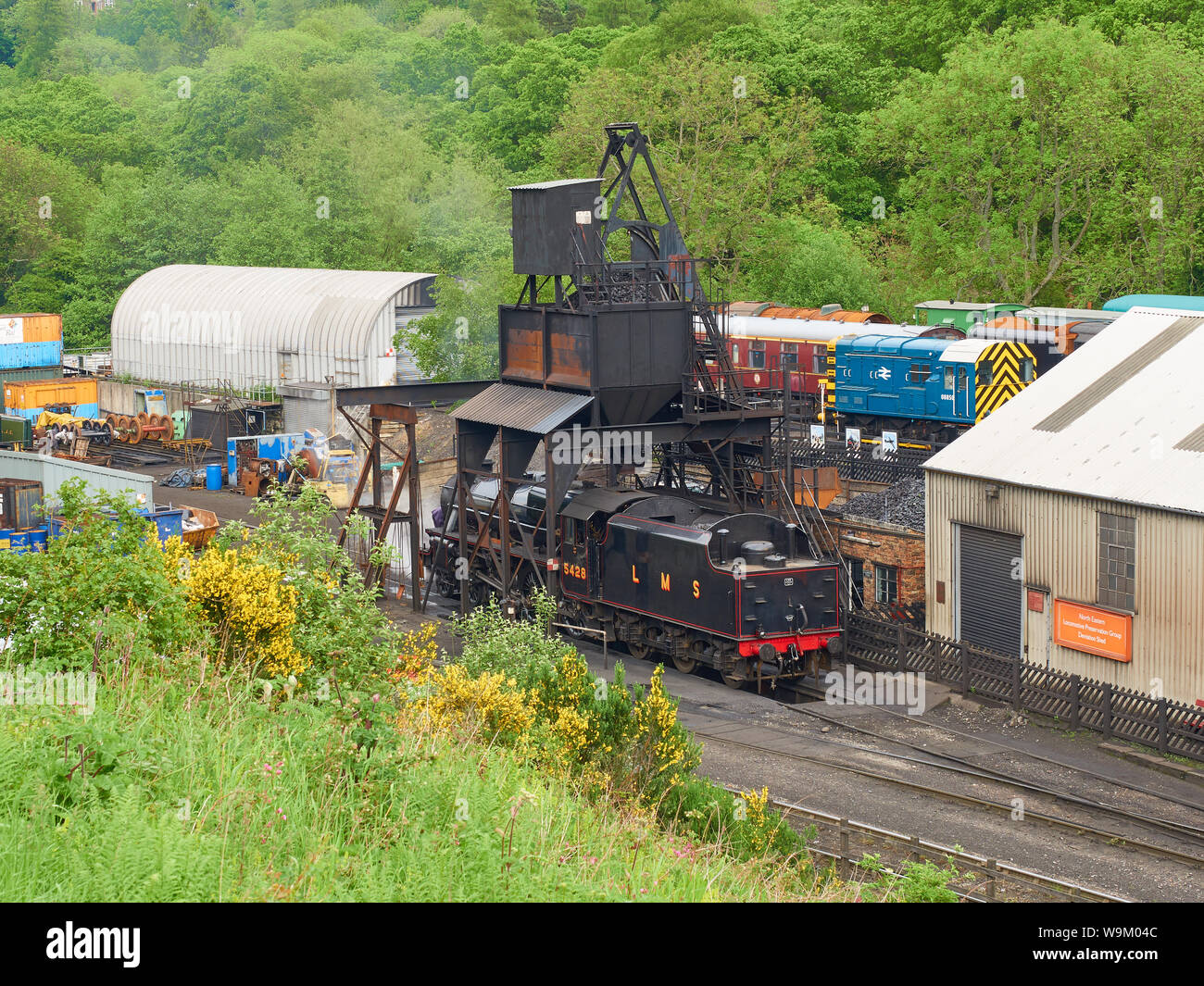 A steam engine locomotive filling with coal at Grosmont engine yard on the volunteer run heritage North York Moors Railway Stock Photo