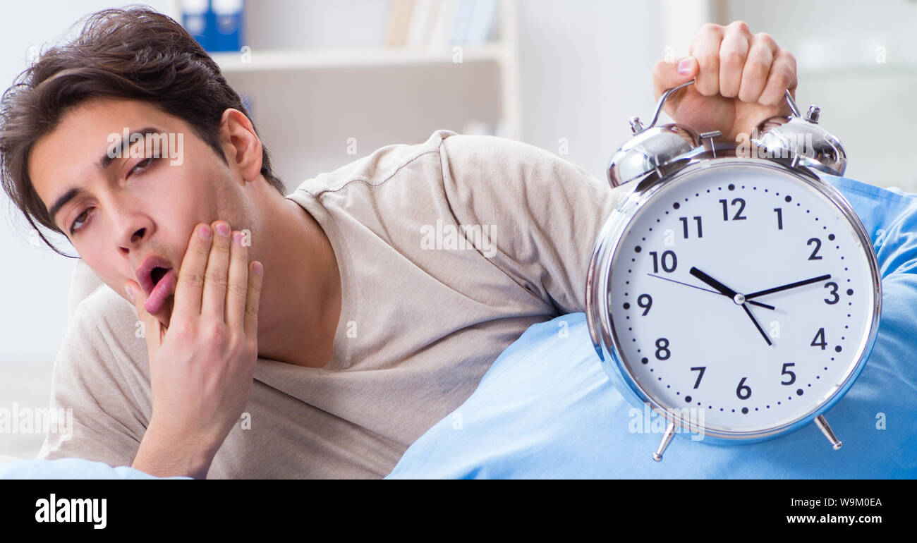 The man having trouble waking up with alarm clock Stock Photo Alamy