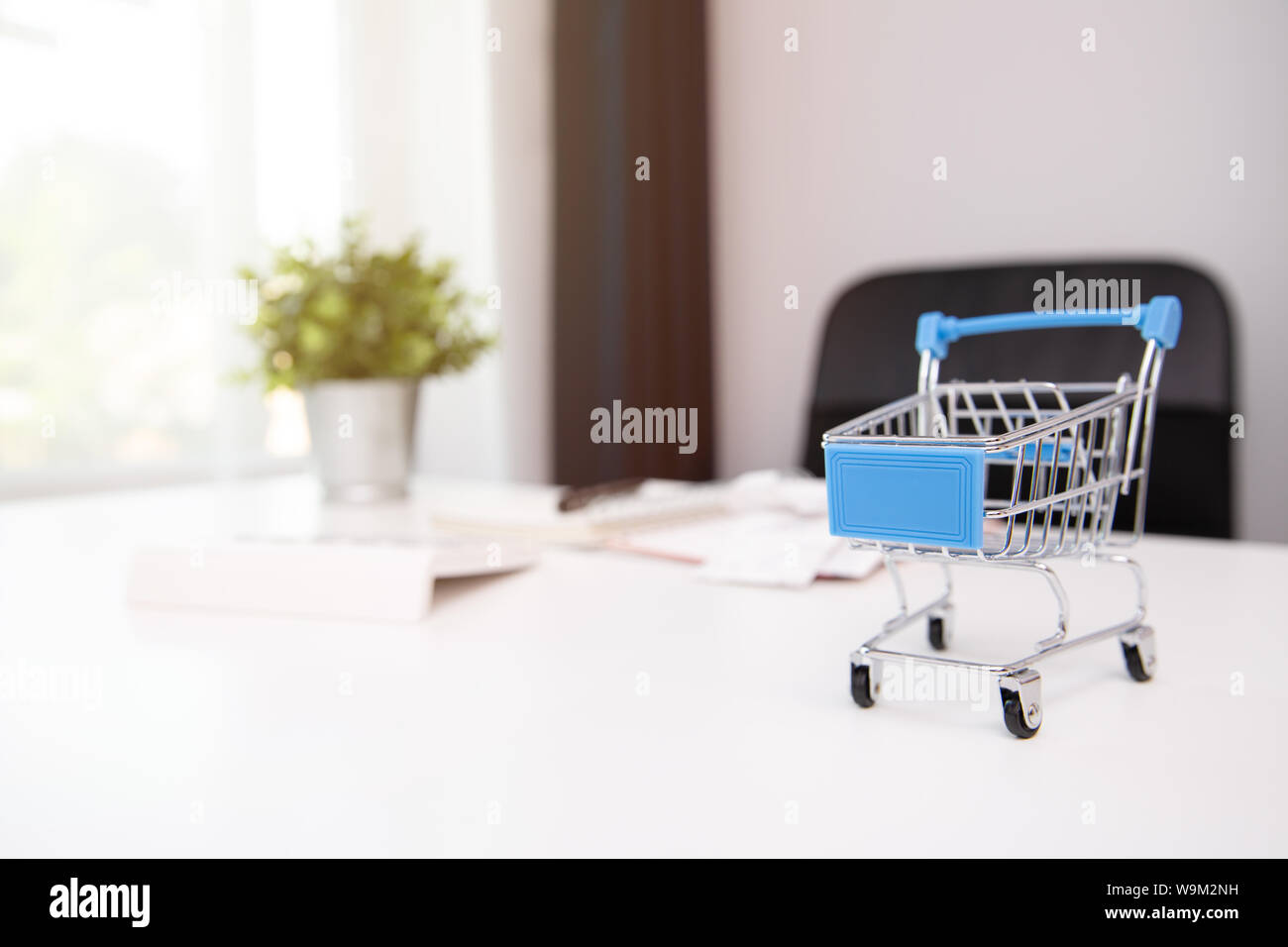 Shopping cart, receipts, notebook and calculator at office workplace. Home finances, investment, economy, saving money concept Stock Photo