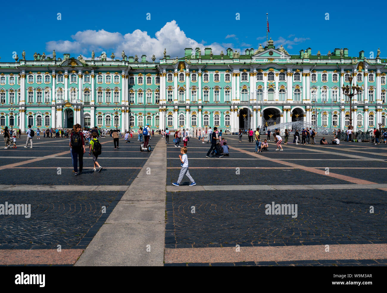 St. Petersburg, Russia -- July 21, 2019. Photo of people walking around in the square outside the Winter Palace in St Petersburg, Russia. Stock Photo