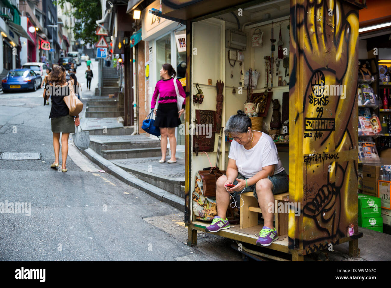 Woman listening to music on her small handicraft store in Hong Kong