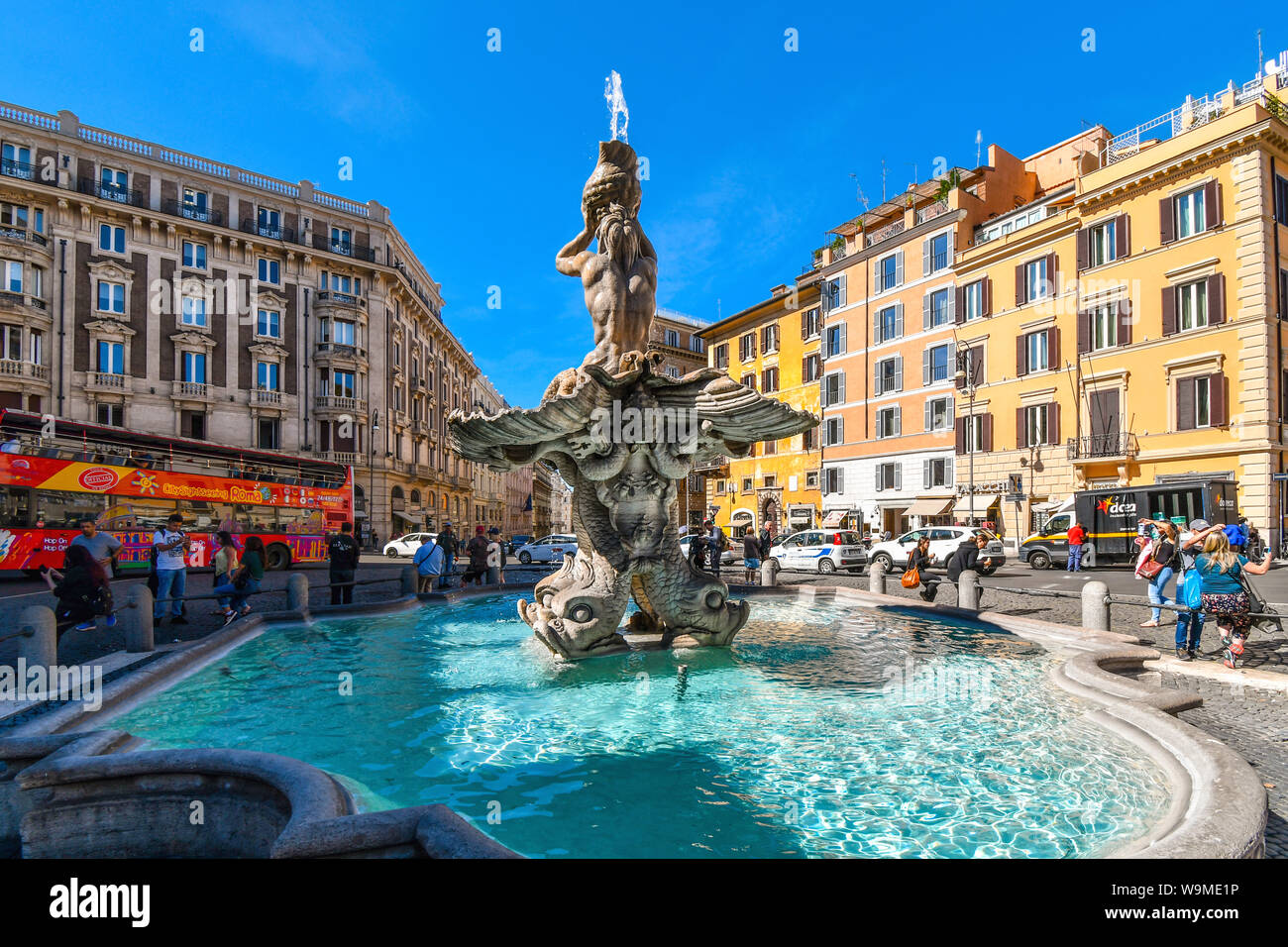 Tourists and locals visit the Triton Fountain in the Piazza Barberini, by Gian Lorenzo Bernini, a masterpiece of Baroque sculpture in Rome, Italy Stock Photo