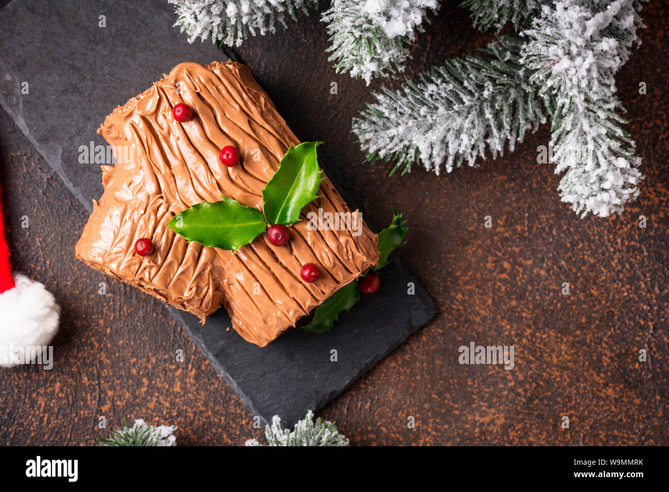 Christmas yule log cake. Traditional chocolate dessert on festive background Stock Photo