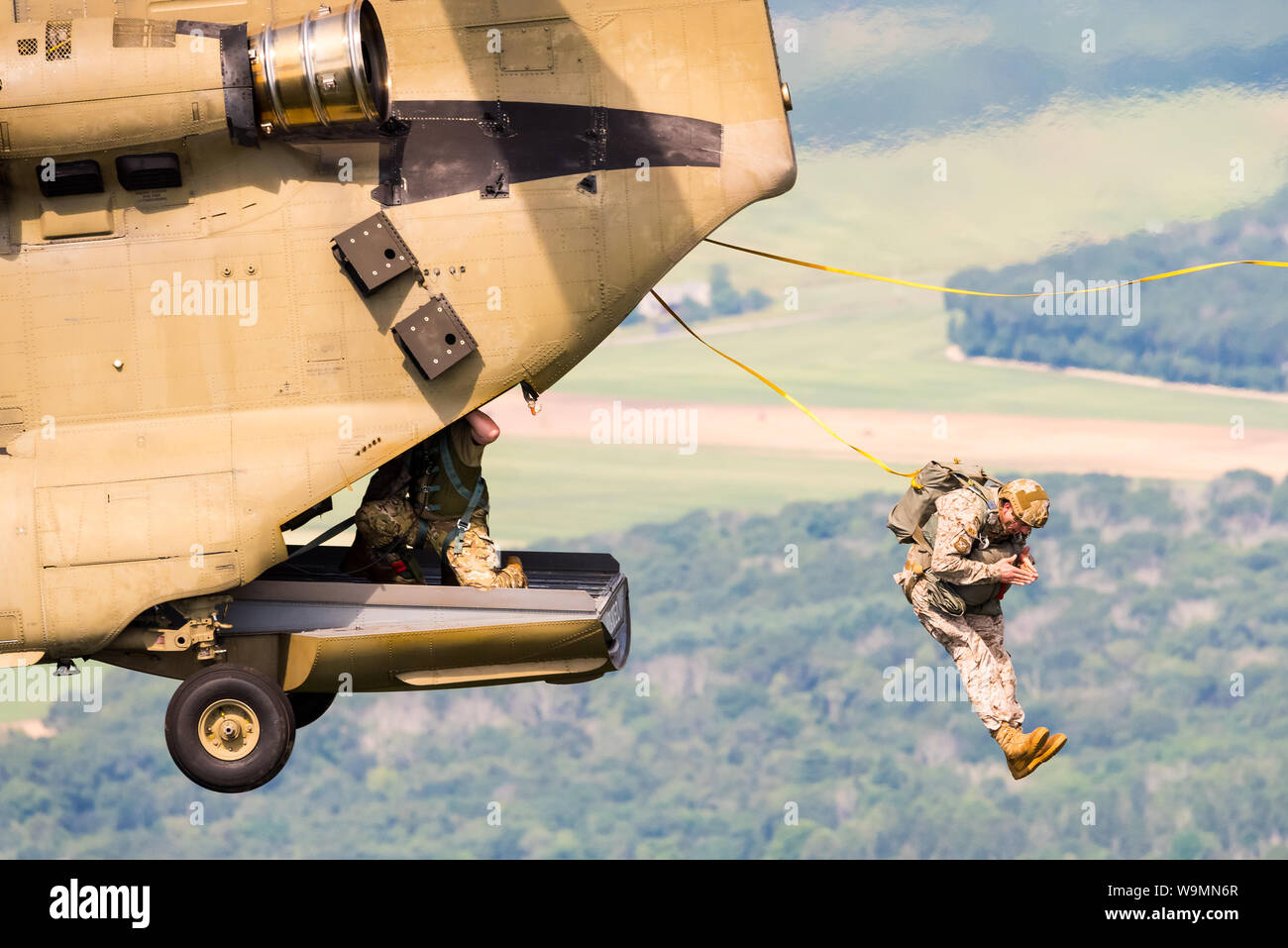 Soldier jumping out of a Chinook at 2019 Leapfest, an international static line parachute training event and competition, hosted by RI Natl. Guard. Stock Photo