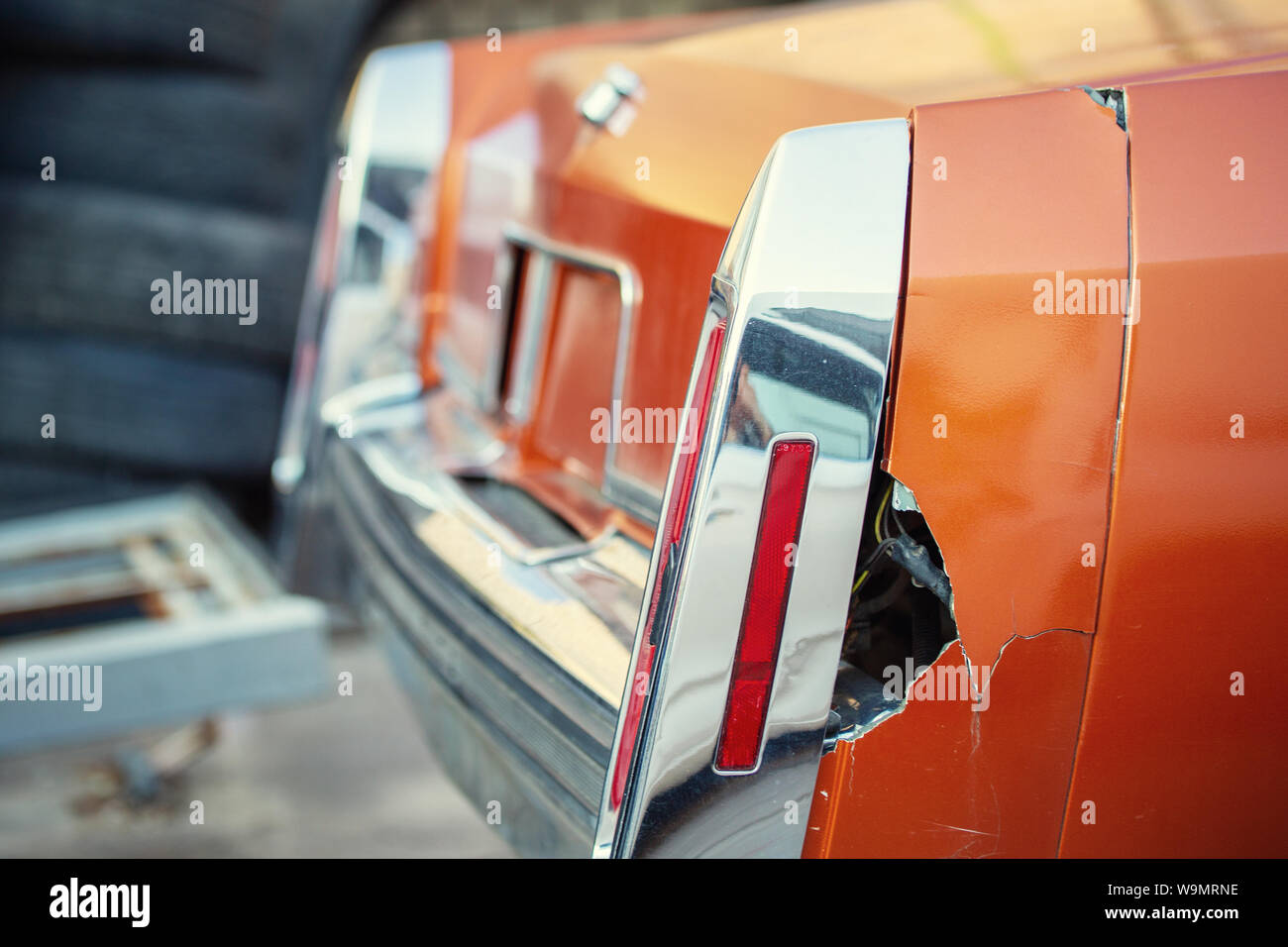 Close-up old retro car wrecked tail wing part with big rusty hole after accident. Vintage vehicle restoration and repair Stock Photo