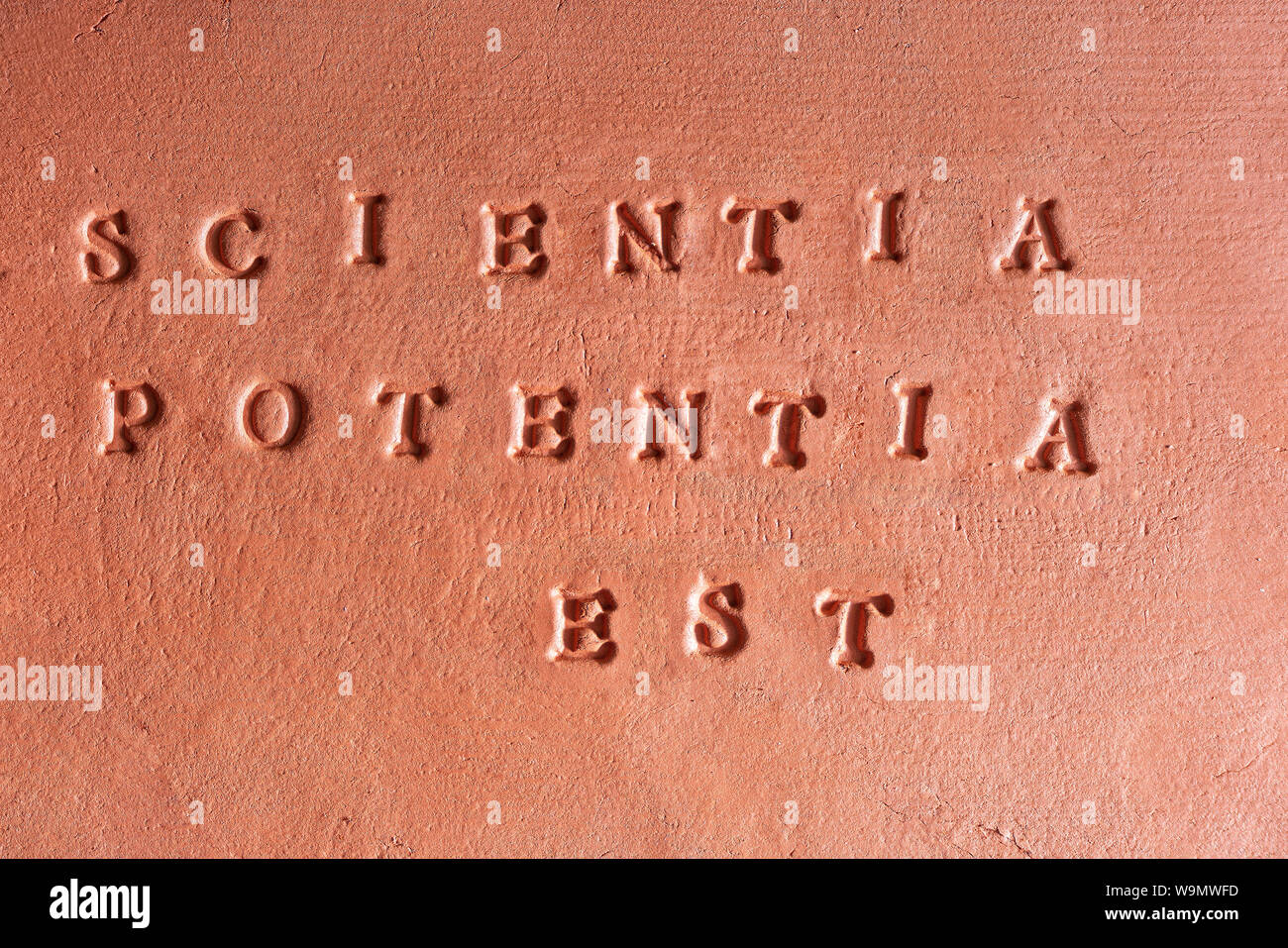 the phrase  “Scientia Potentia Est” written in Latin on a terracotta tablet Stock Photo