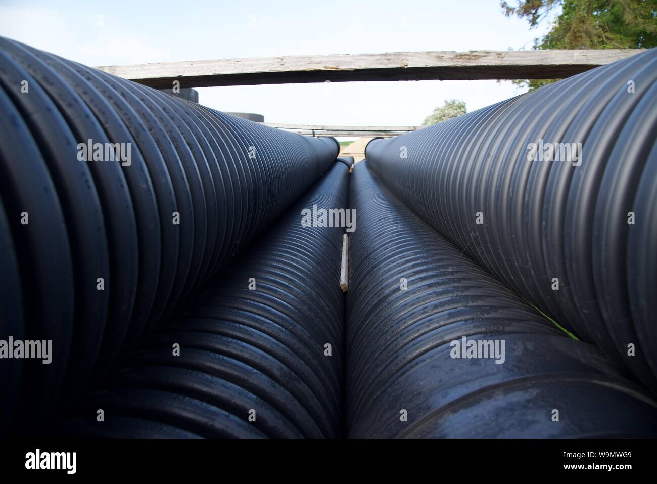 Large bore PVC pipes stacked and awaiting use on a storm drain