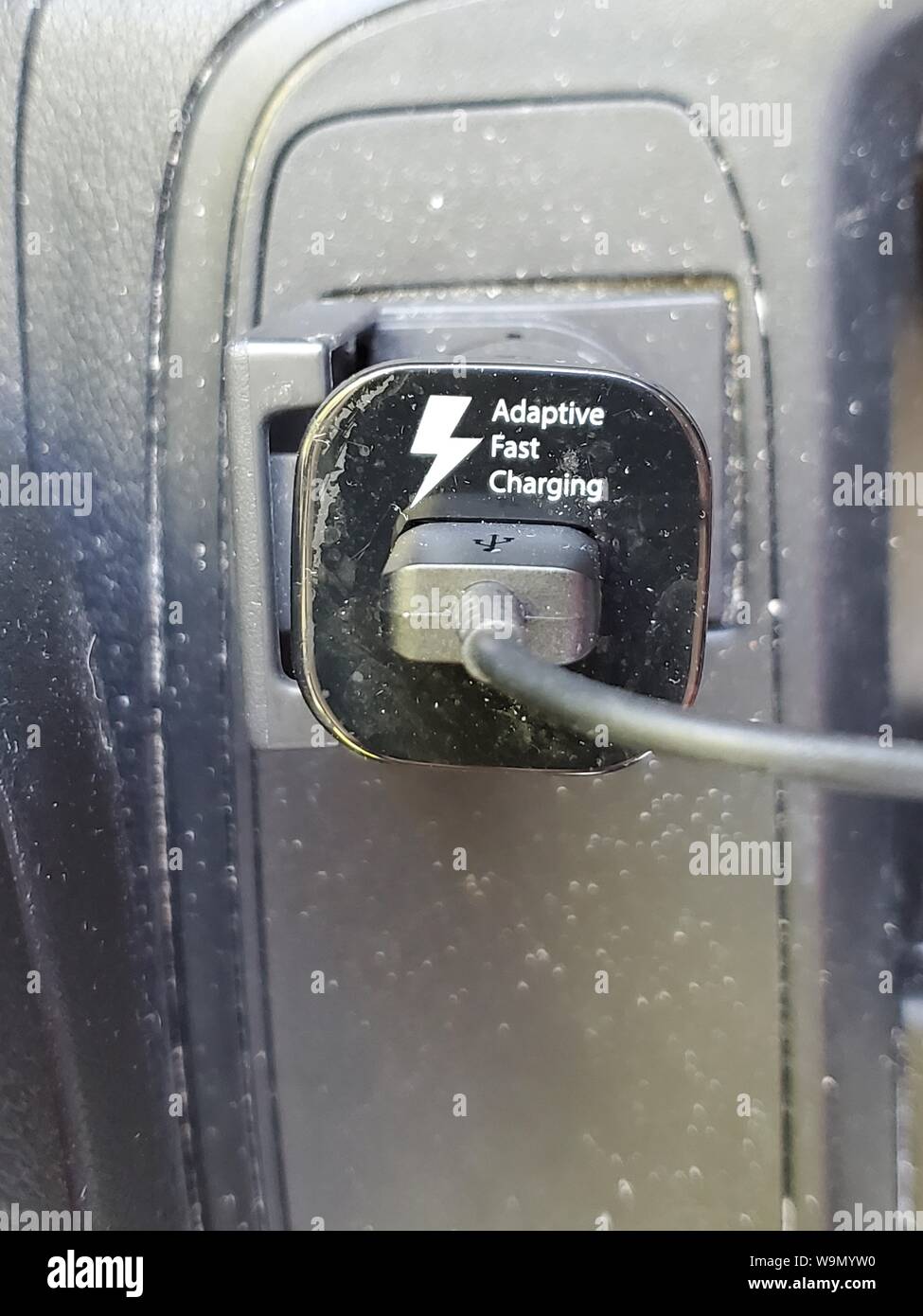 Close-up of a vehicle cellular phone charger with text reading Adaptive Fast Charging and USB cable, August 13, 2019. () Stock Photo