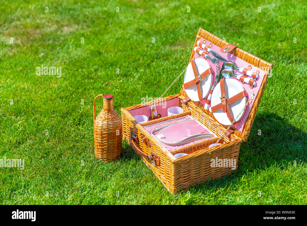 Picnic basket on green sunny lawn in the park Stock Photo - Alamy