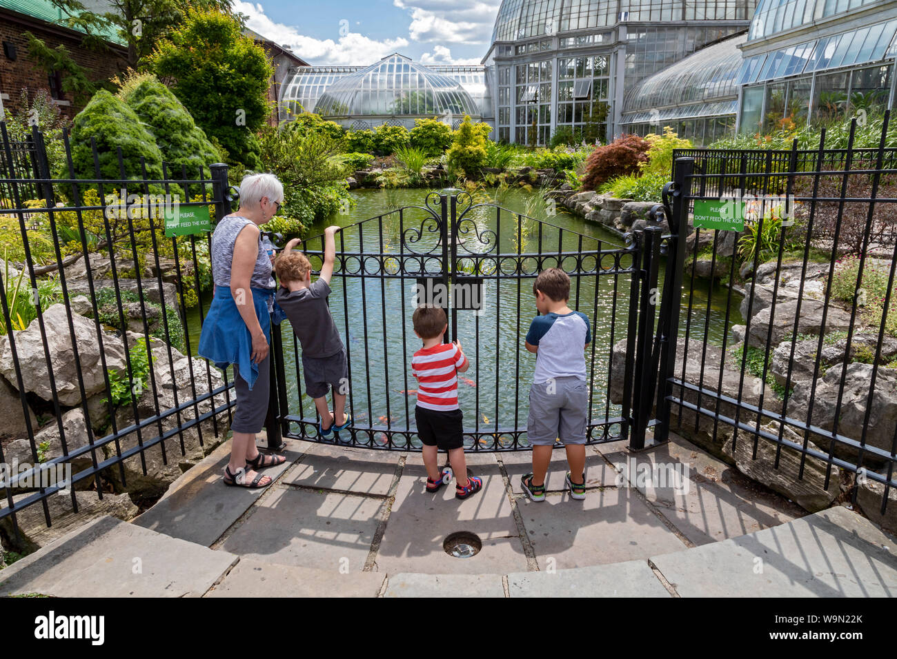 Detroit, Michigan - Children watch fish in the koi pond at the Belle Isle Aquarium. Designed by Detroit architect Albert Kahn and opened in 1904, is t Stock Photo