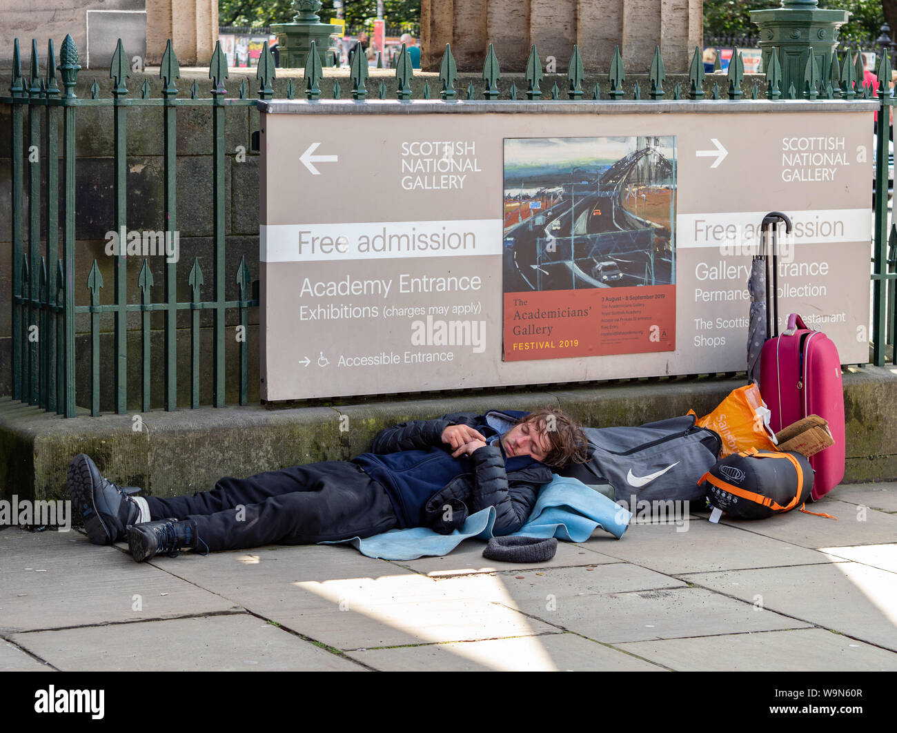 A rough sleeper on the pavement outside The Royal Scottish Academy at the bottom of the Mound, Edinburgh, Scotland, United Kingdom. Stock Photo