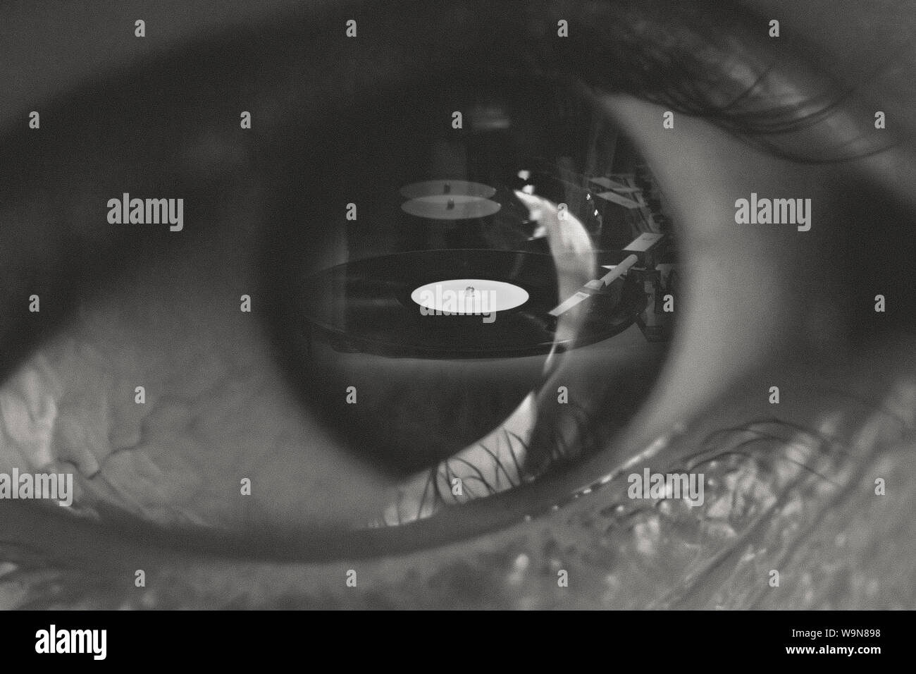 Music is my relligion. Phonograph record in the pupil of the eye. Black and white collage concept image of sound lover. Stock Photo