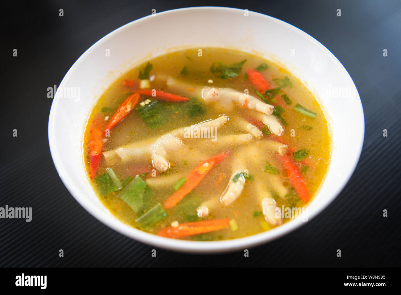 Chicken Feet Spicy Soup / Chicken Foot with hot and sour soup bowl with fresh vegetables Tom Yum