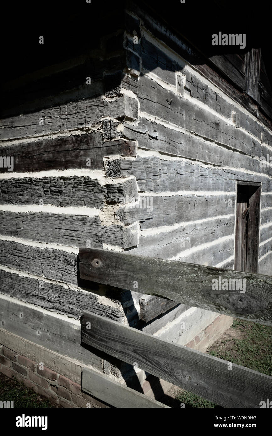 A Close Up Of The Hand Hewn Log Cabin With Wooden Fence Attached