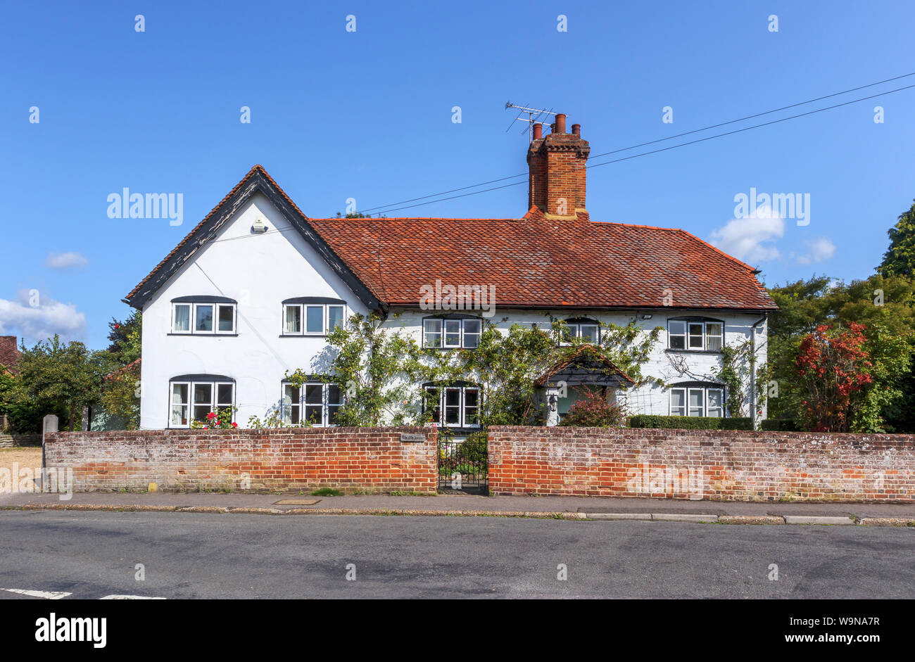 Real estate roadside view of a large property, a white detached house