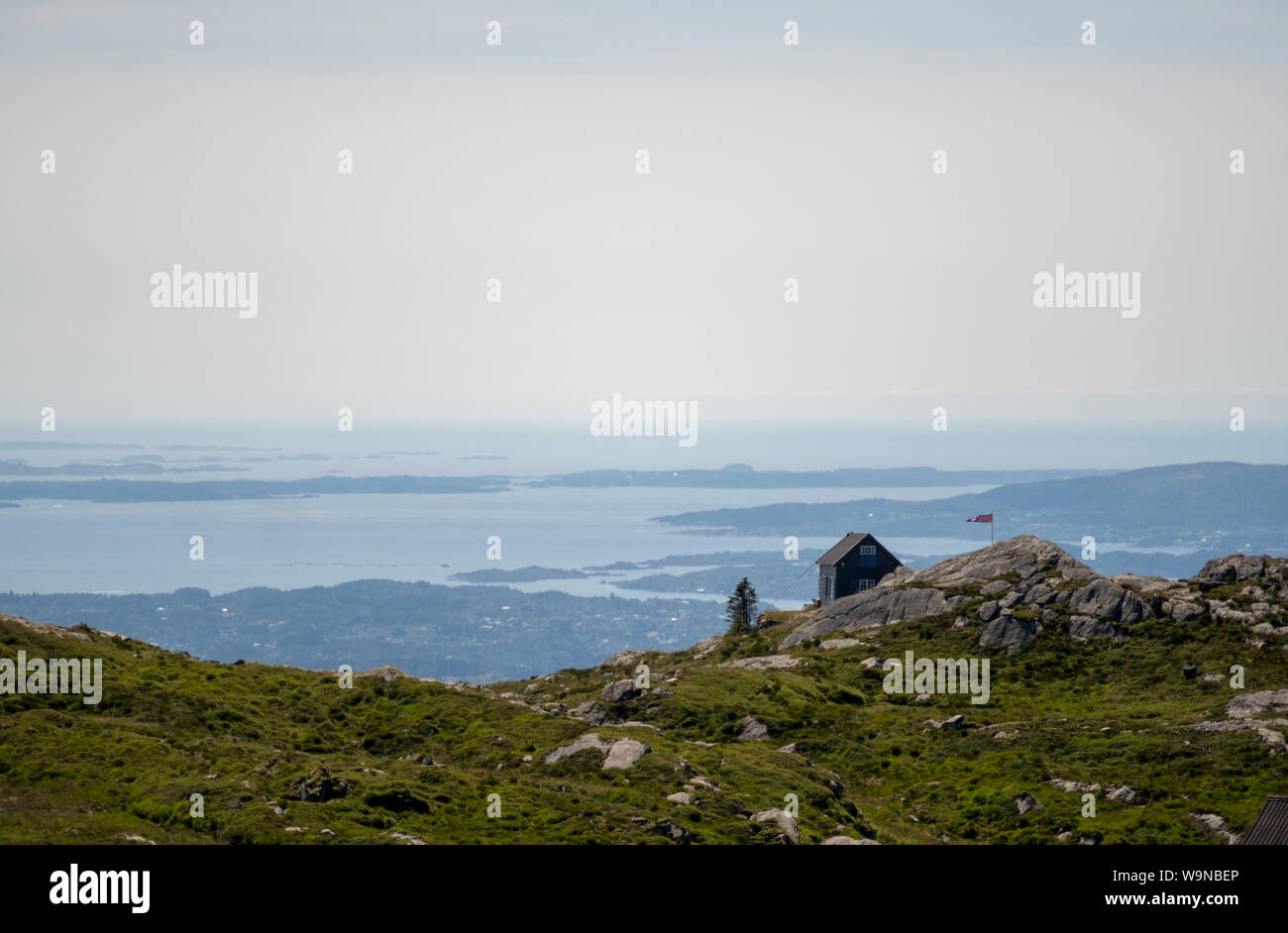 View of cabin on mountaintop with islands in background at Mount Ulriken, Bergen Stock Photo