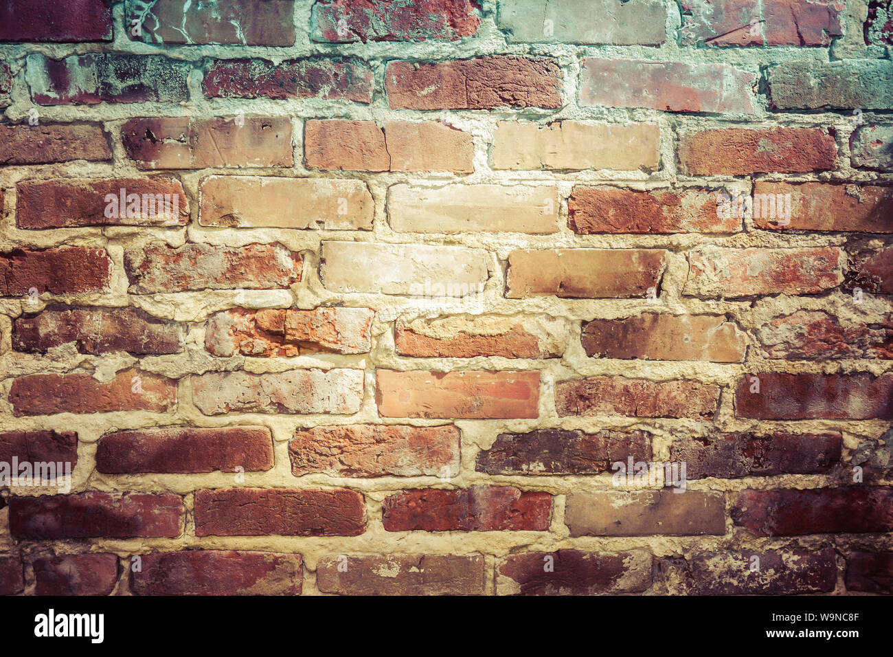 a close up of light and shadow falling  across  an old, fading, red brick wall Stock Photo