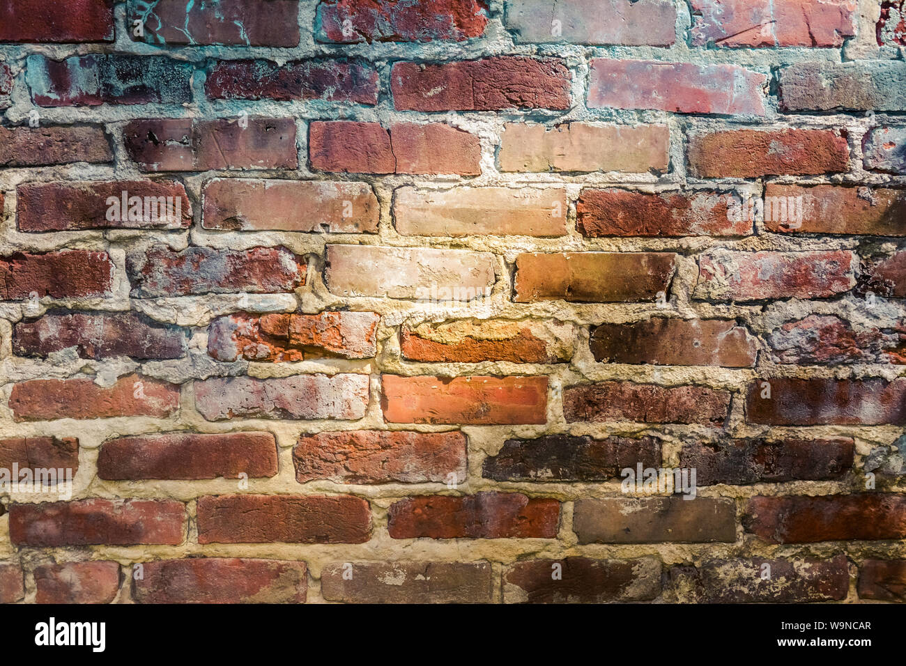 a close up of light and shadow falling  across  an old, fading, red brick wall Stock Photo