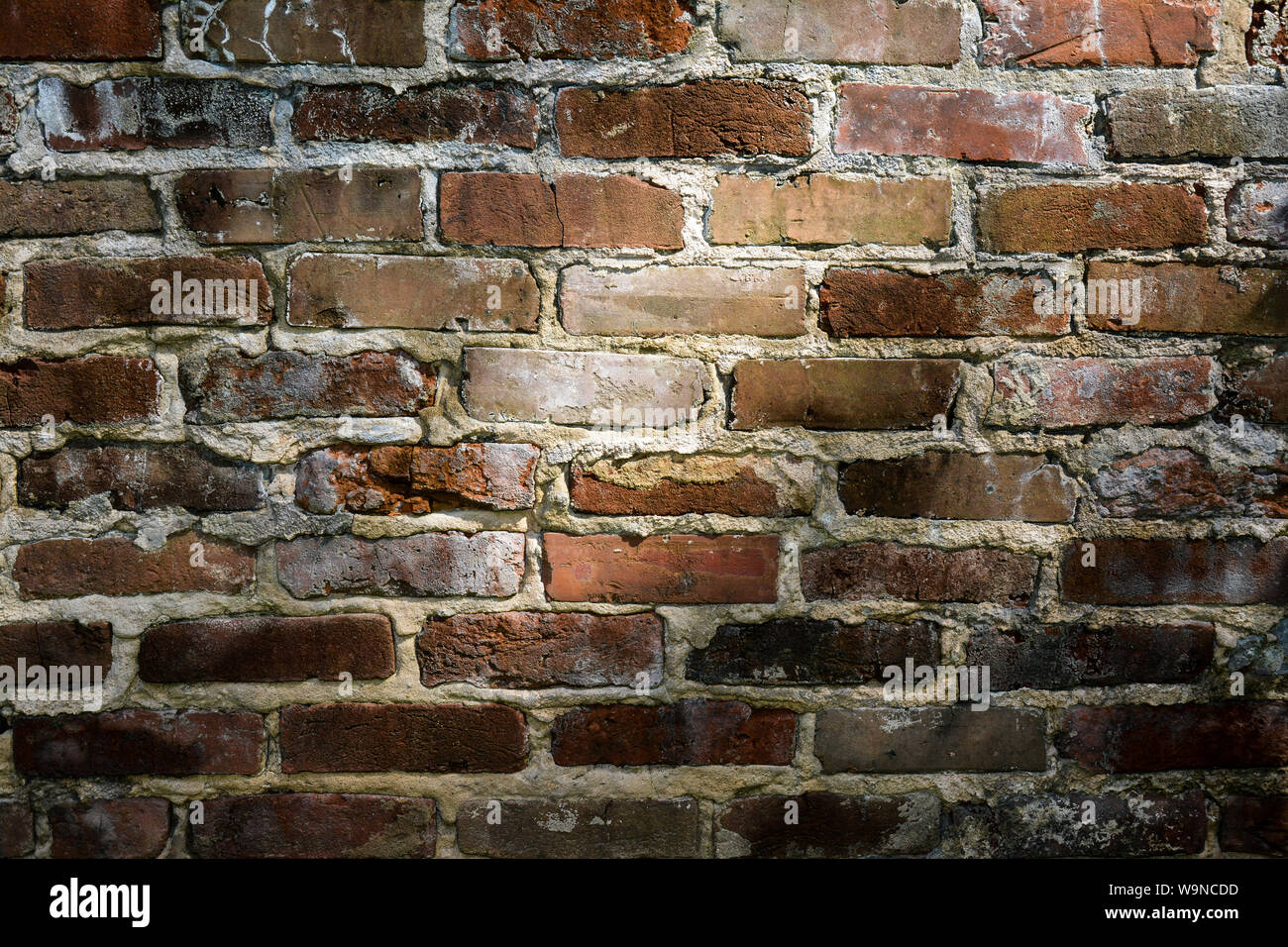 a close up of light and shadow falling  across  an old, fading, red brick wall Stock Photo