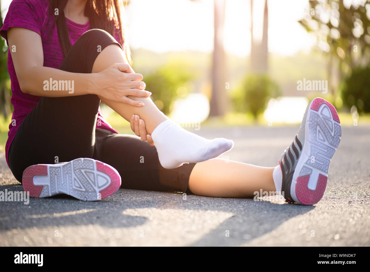 Ankle sprained. Young woman suffering from an ankle injury while