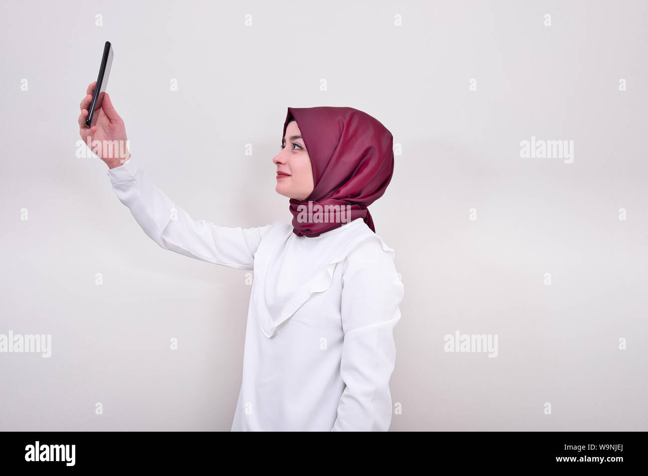 Muslim woman taking portrait selfie, girl in hijab and she taking selfie with mobile phone Stock Photo