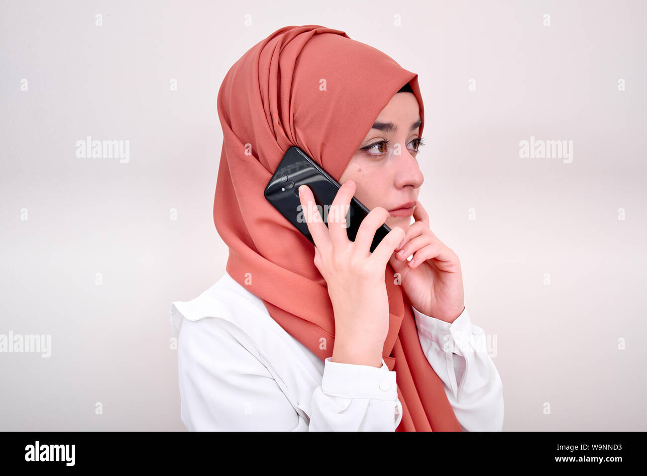 Muslim woman calling, hijab girl standing and calling with mobile phone Stock Photo