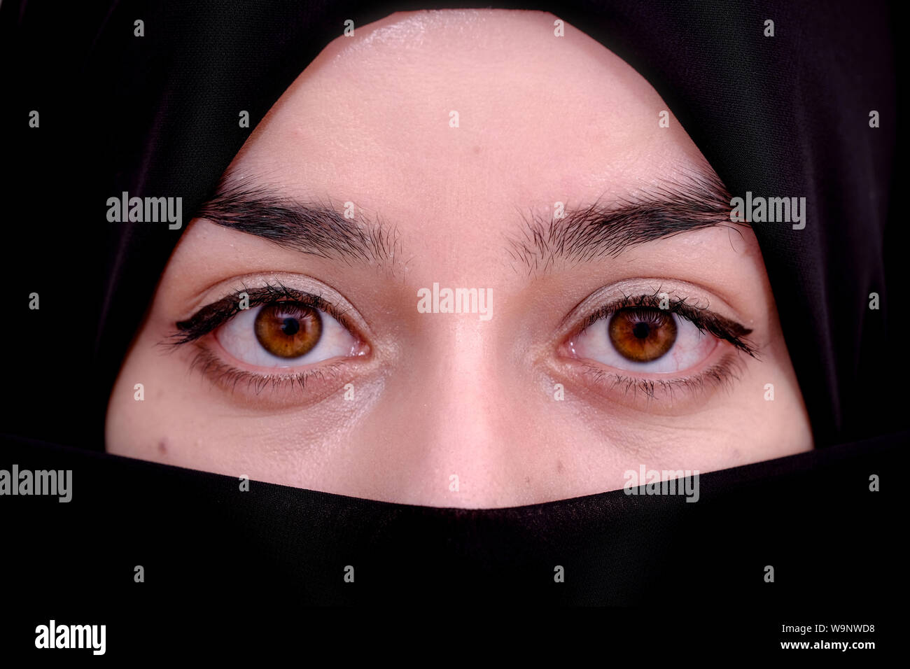 Muslim woman wearing red hijab veil, Afghan girl wear the burka or burqa, close up portrait photo Stock Photo