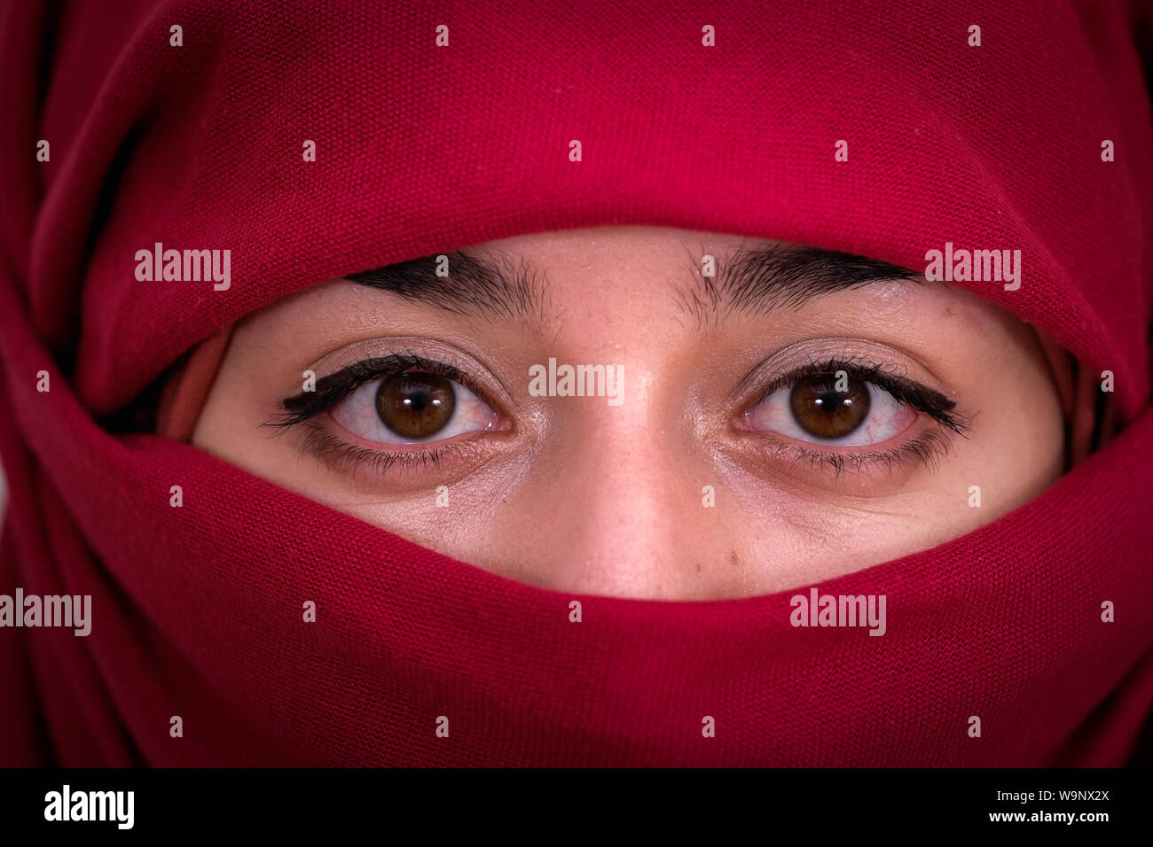 Muslim woman wearing red hijab veil, Afghan girl wear the burka or burqa, close up portrait photo Stock Photo
