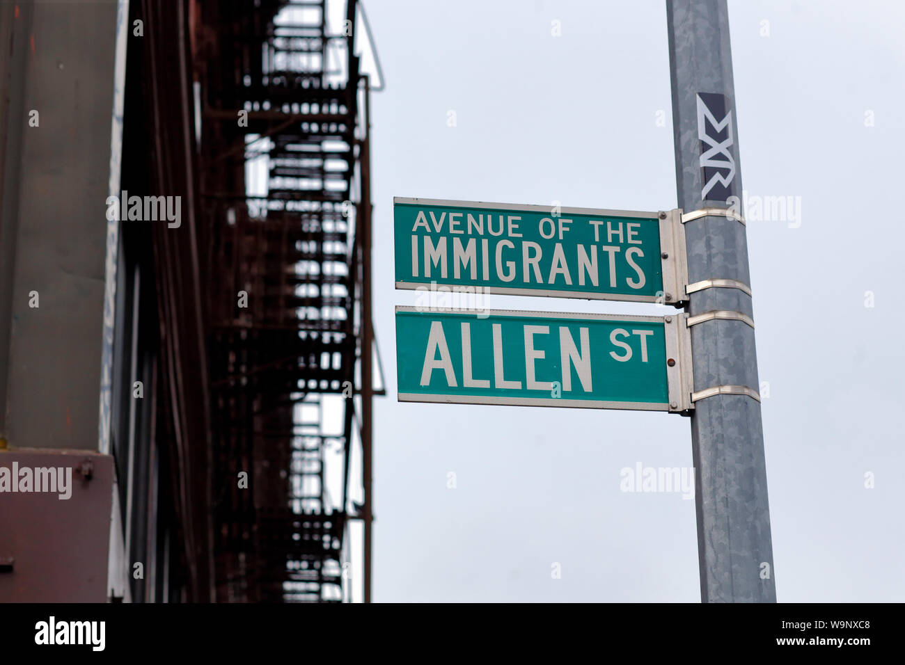 Street signage proclaiming Allen Street as Avenue of the Immigrants in New York City's Lower East Side Stock Photo