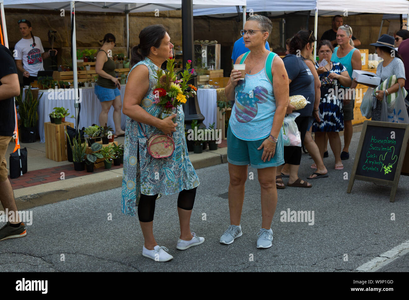 Two women discuss the day's shopping at Fort Wayne's Farmers' Market in