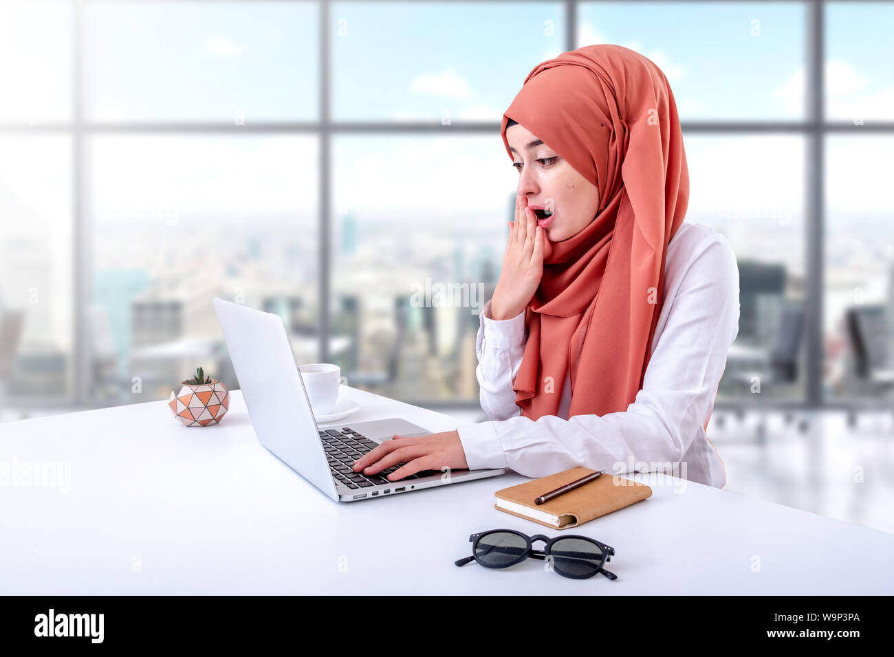 Muslim woman working with computer in office, hijab muslim girl confused or bewildered Stock Photo
