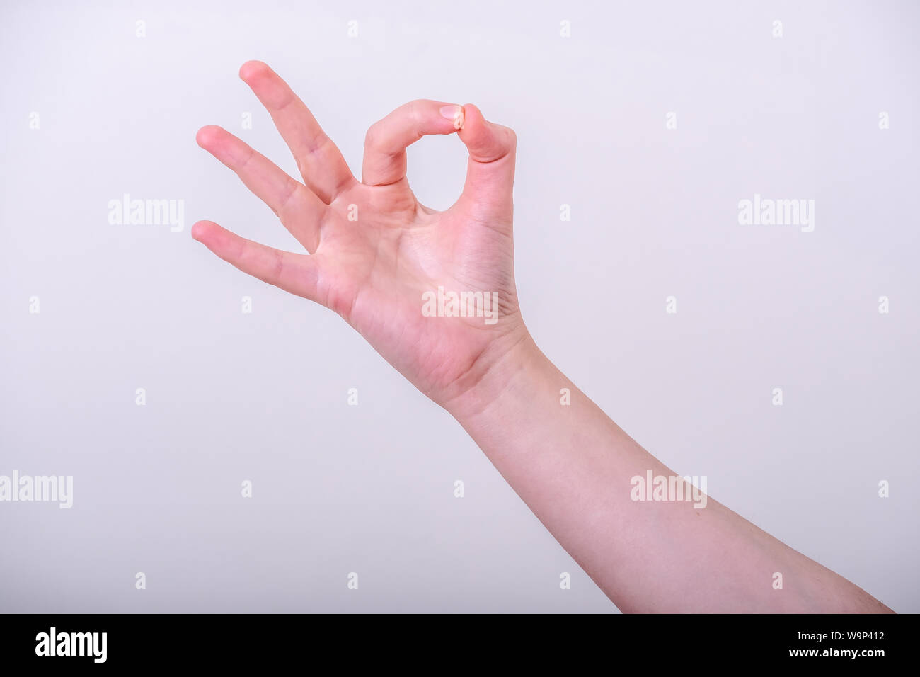 Woman hand pointing up okay gesture, woman gesturing okay, yes, accepting hand sign, isolated photo Stock Photo