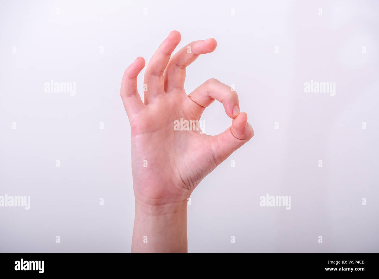 Woman hand pointing up okay gesture, woman gesturing okay, yes, accepting hand sign, isolated photo Stock Photo