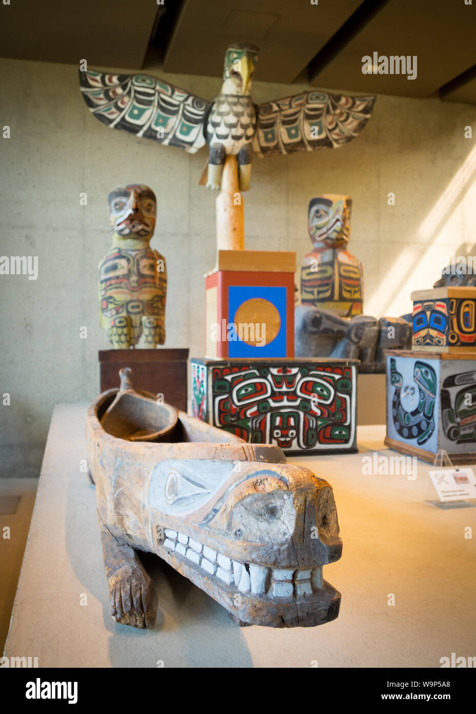 A potlatch serving dish and various First Nations totem poles and art in the University of British Columbia Museum of Anthropology in Vancouver Canada Stock Photo