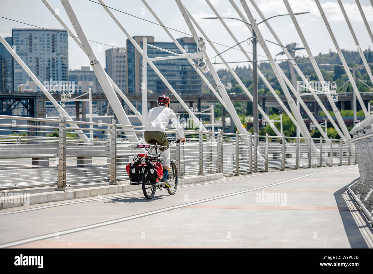 Man Cyclist in sports outfit rides a bicycle on the Tilikum Crossing Bridge. The use of a bicycle as the main transport for many enthusiasts has grown Stock Photo