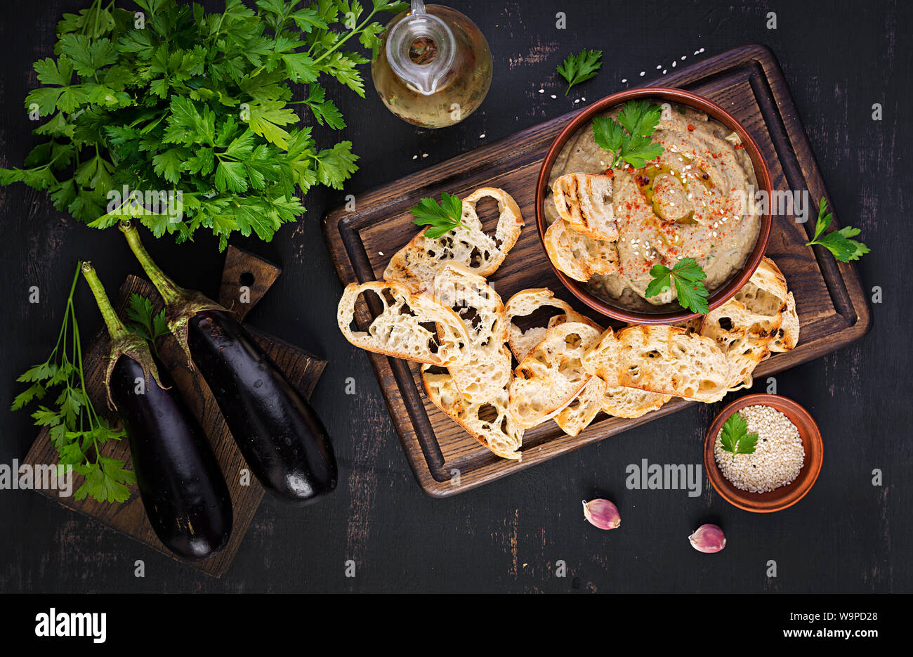 Baba ghanoush vegan hummus from eggplant with seasoning, parsley and toasts. Baba ganoush. Middle Eastern cuisine. Top view, overhead Stock Photo