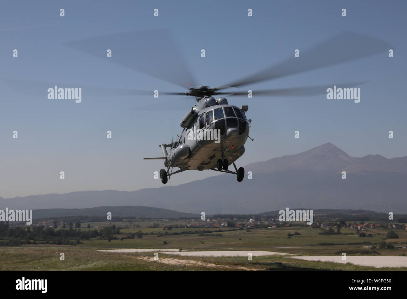 A Croatian Air Force transport helicopter, MI-17, prepares to land at Camp  Bondsteel, Kosovo, Aug. 6, 2019. The role of the flight engineer is to  advise the pilot of any problems, make record of any flight issues and  observe the overall performance of the helicopter. The MI-17 is a medium  twin-turbine transport helicopter and is recognizable by its clamshell cargo  doors. (U.S. Army photo by Spc. Grant Ligon, 40th Public Affairs Detachment) Stock Photo