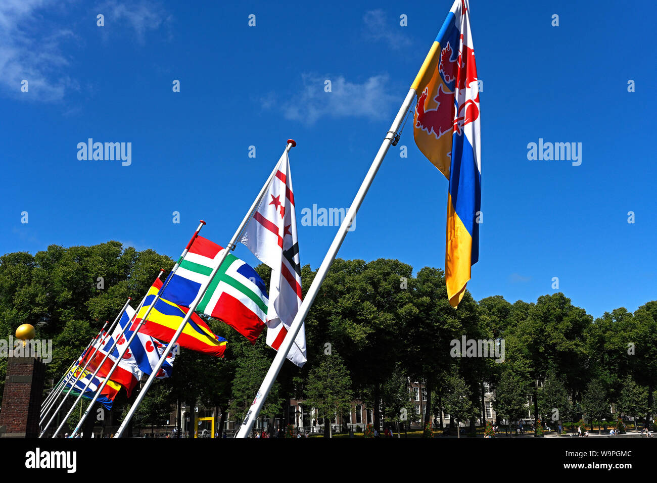 den haag, netherlands - 2019.08.07:  flags of dutch provinces at hofvijver / buitenhof near binnenhof, background people at lange vijverberg Stock Photo