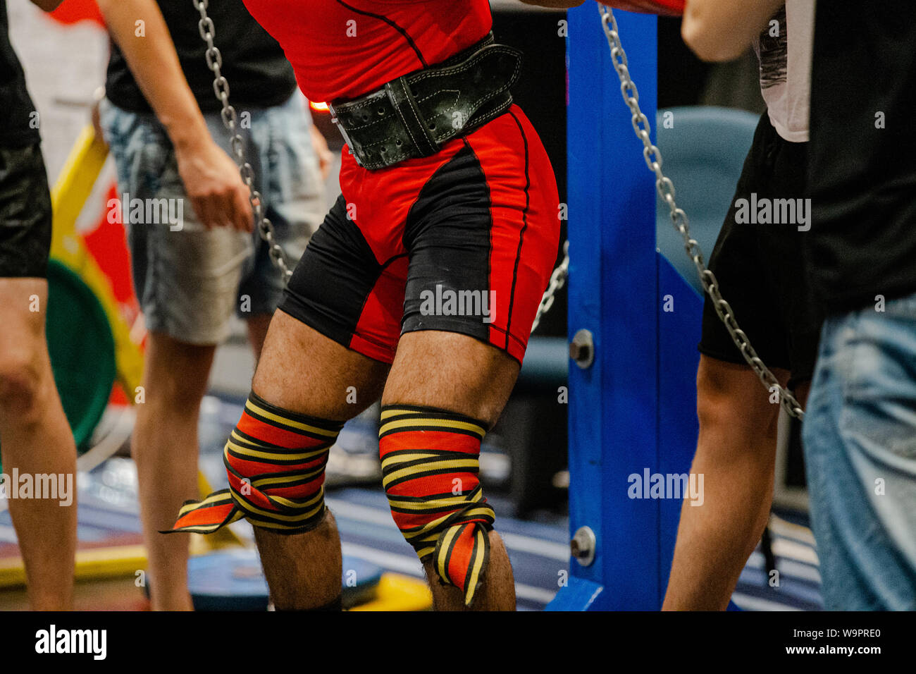 male powerlifter knee wraps squatting competition in powerlifting Stock